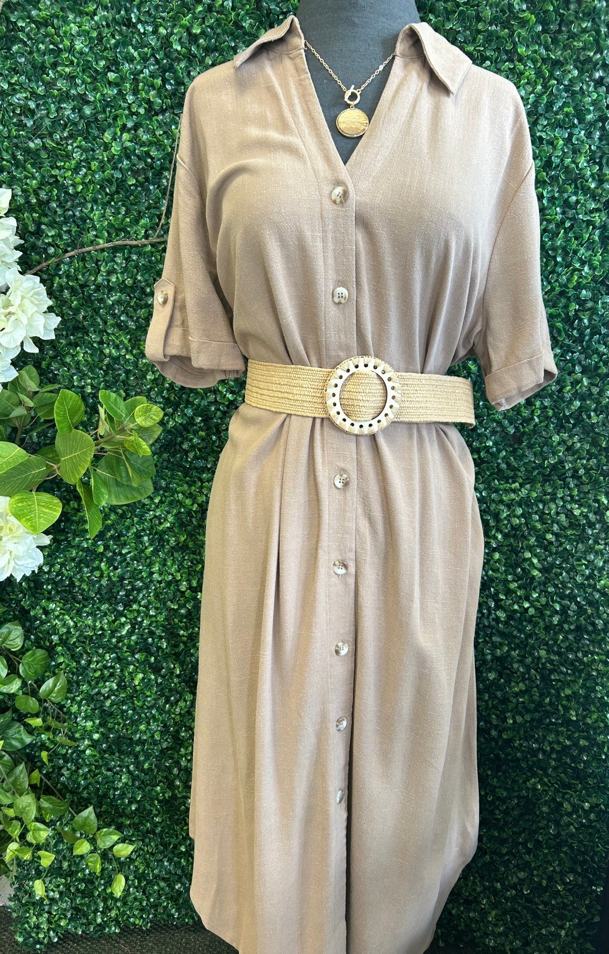Trendy button-up dress with belt for women at local boutique.