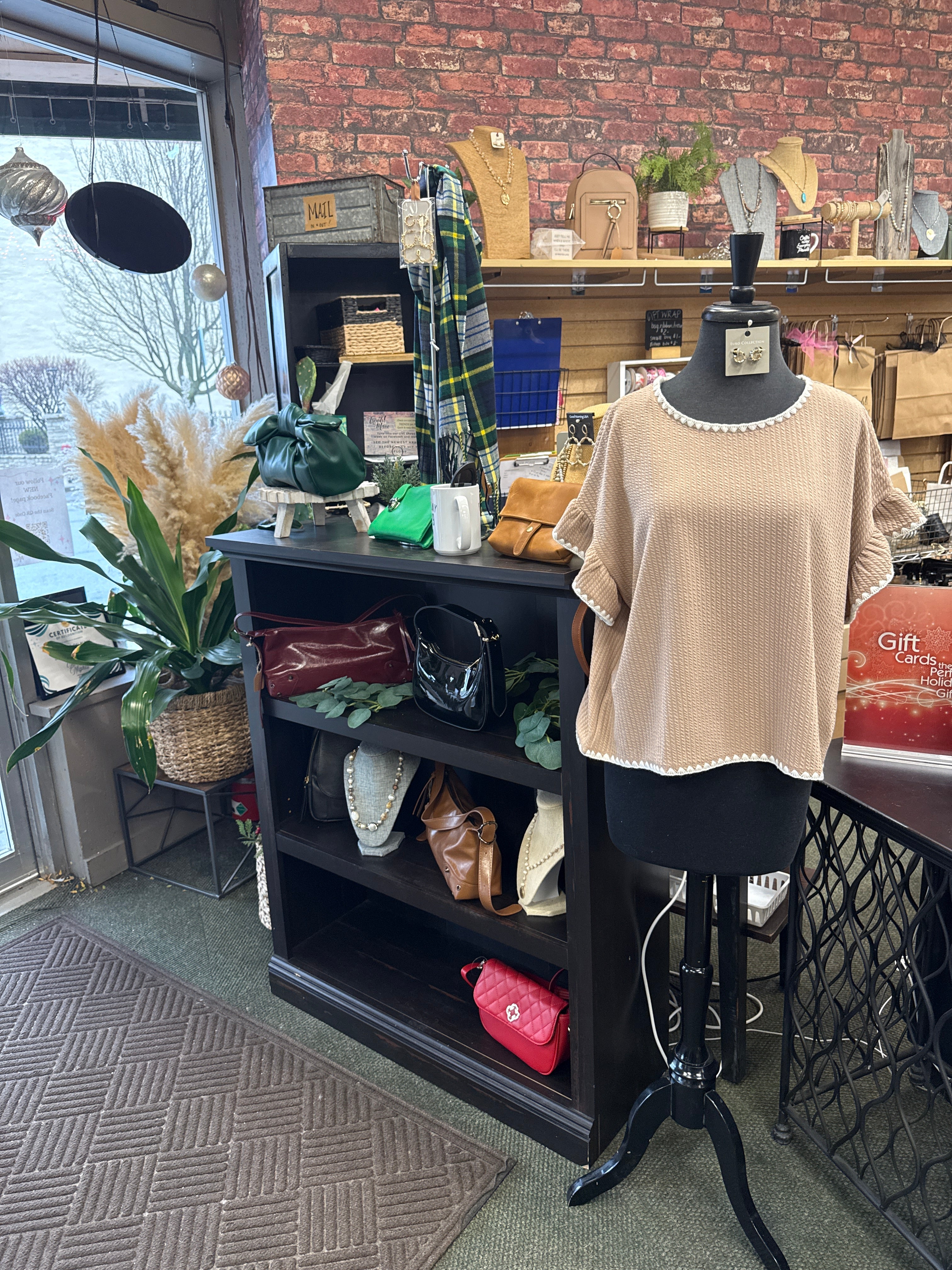 Trendy women’s boutique clothing display with stylish outfits and accessories in a cozy shop.