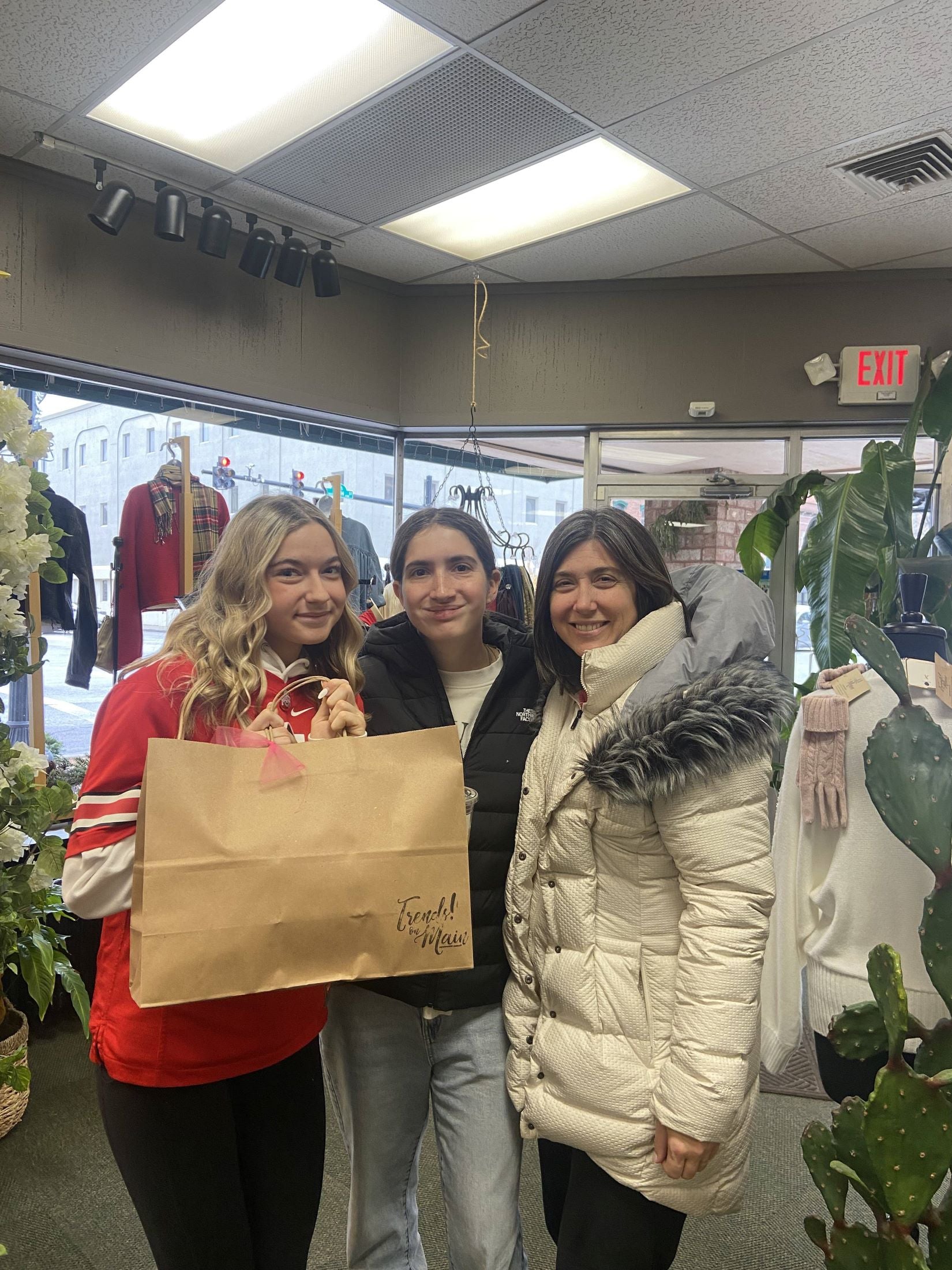 Three women shopping at a trendy local boutique, showcasing affordable women's fashion and stylish outfits.
